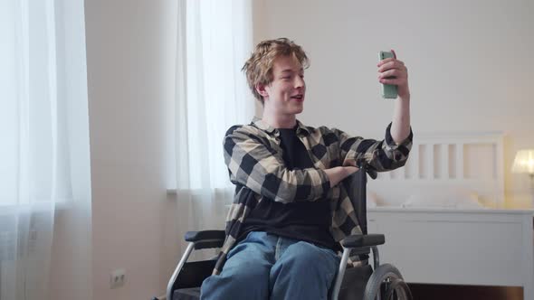 A Beautiful Disabled Man is Talking with His Friend on the Internet