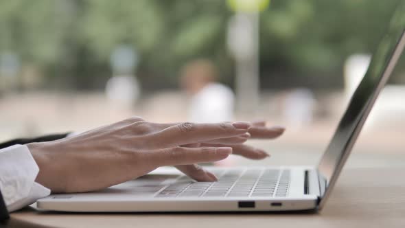 Side View of African Woman Hands Typing on Laptop