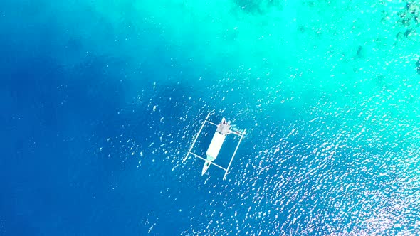 Island In Maldives - Boat Floating In The Bright Blue Ocean Water With Coral Reefs In The Bottom On