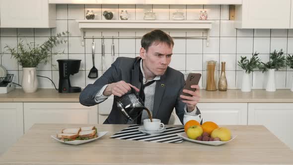 Man Pouring Coffee While Using Smartphone at Home