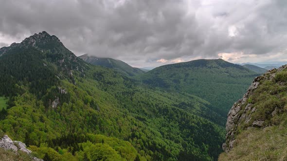 Dramatic Grey Clouds over Green Forest Mountains in Spring Nature