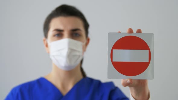 Doctor or Nurse in Face Mask Showing Stop Sign