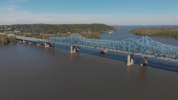 Drone footage of McClugage Bridge in Peoria, Illinois. A paddleboat slowlyes past the bridge