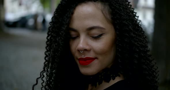 Pretty Woman Is Smiling and Looking at Camera on Street of City in Daytime