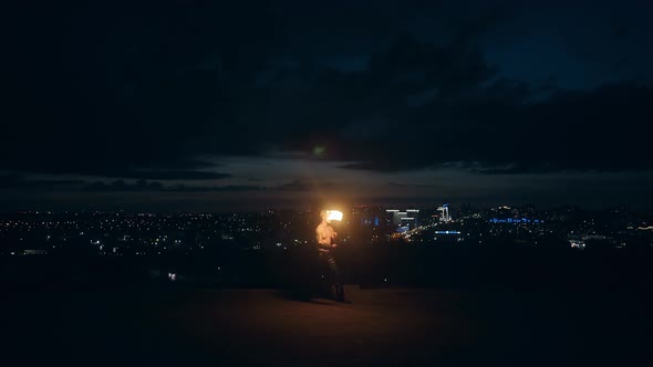 Young Blond Male Getting Ready To Perform Fire Show, Fire Tricks, Breaths Fire in the Middle of the