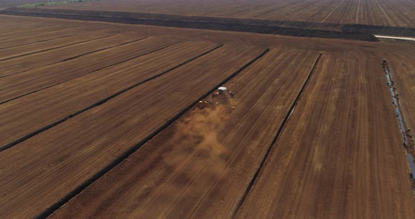 Peat Harvesting Tractor Extracting Turf in Drained Bog Aerial View