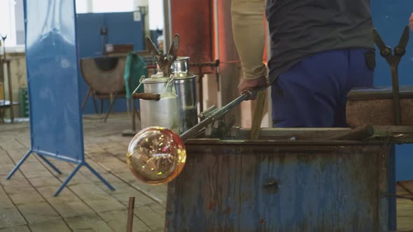 Glass Blower Shaping a Bubble of Melted Glass on a Rod