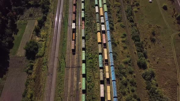 Flying Above Industrial Railroad Station with Cargo Trains