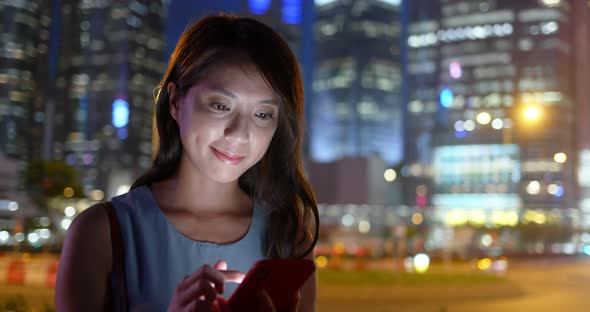 Woman use of mobile phone in city at night