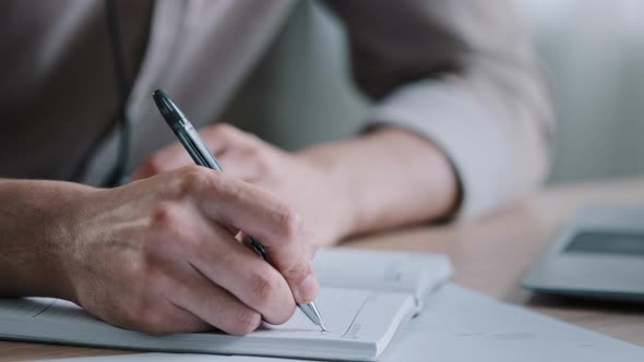 Close Up Unrecognizable Righthanded Man Sit at Office Desk Male Worker Hold Pen Take Notes in Dairy