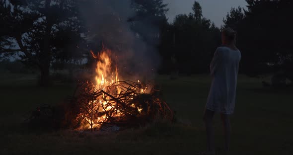 Beautiful Natural Woman Looking at Burning Bonfire