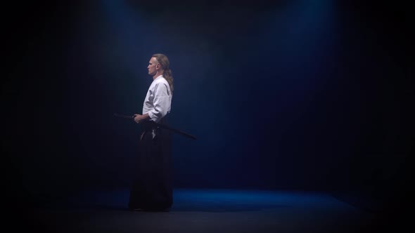 Aikido Master Technique Demonstration with Japanese Sword Katana. Silhouette on Black Studio