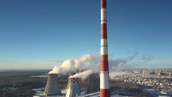Aerial View Chimney and Cooling Towers Against Town and Sky