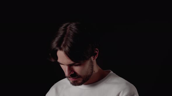 Trendy Young Man using and typing on his smart phone, close, black background