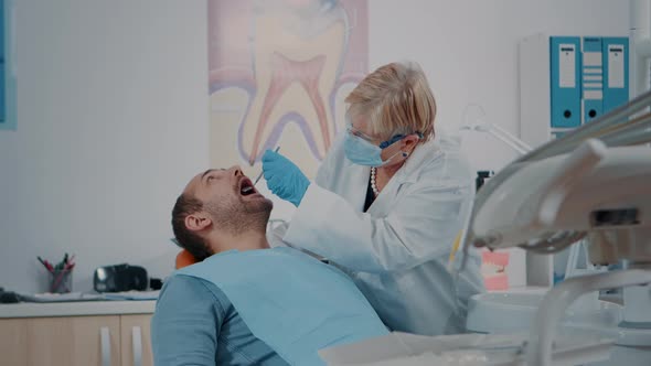 Patient Opening Mouth and Dentist Examining Dentition Work