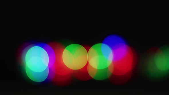 Multiple multicoloured lights flickering on black background