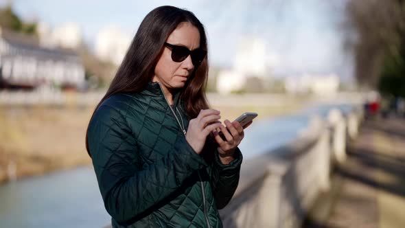 Closeup of an Adult Beautiful Woman a Student on the Street an Attractive Woman Holding a Smartphone