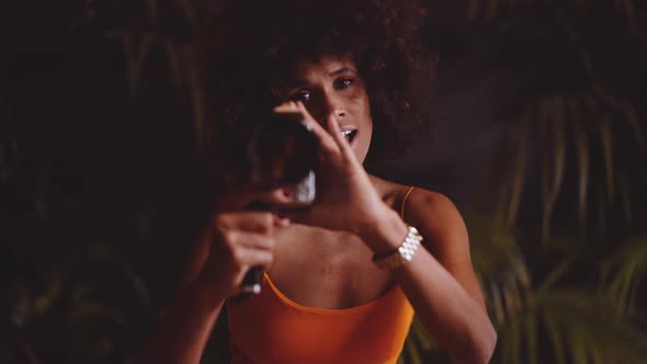 Woman With Afro Hair In Orange Dress Using Vintage 8Mm Camera