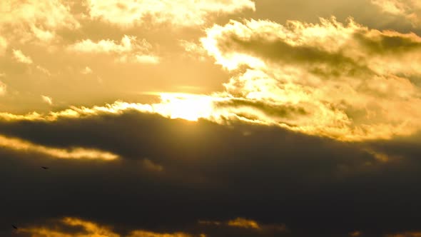 Amazing Sunset Through the Cumulus Clouds in the Orange Sky. Majestic Timelapse