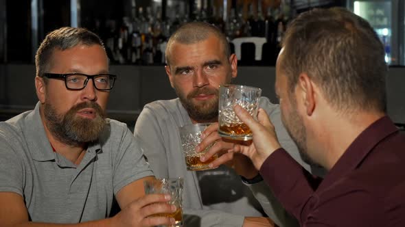 Happy Mature Man Smiling To the Camera While Drinking Whiskey with Friends