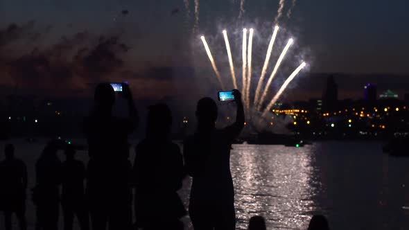 A Group of People During a Firework Near a River