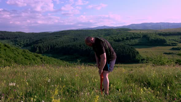 Man training outdoors. Sunset, over green hill