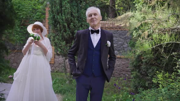 Satisfied Senior Greyhaired Senior Groom Putting Hands in Pockets Smiling Looking at Camera