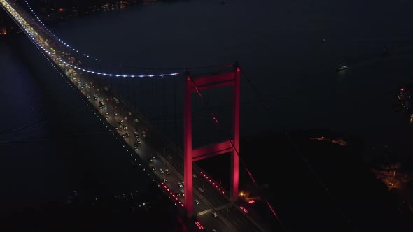 Red Bosphorus Bridge in Istanbul at Night with Car Traffic Into the City, Establishing Aerial