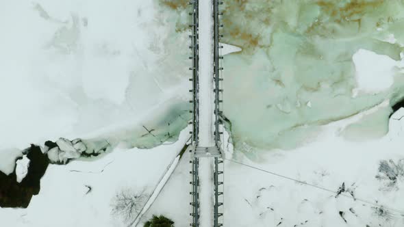 Top-down View Of Simple Suspension Bridge Across Icy River At Winter Season In Haugastol, Norway. -