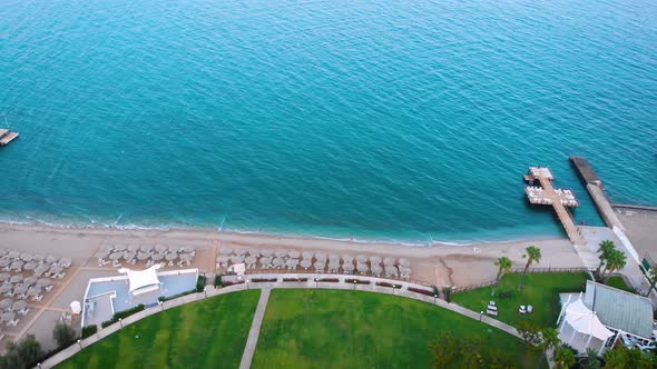 Flight Over the Beach with Umbrellas Towards the Pool in a Luxury Hotel