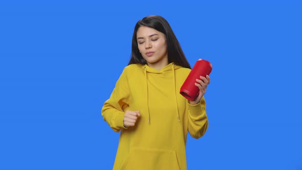 Portrait of Brunette Listening to Music with Bluetooth Portable Speaker and Dancing