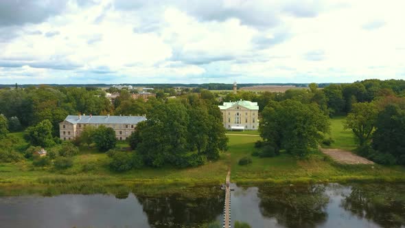 Mezotne Palace and Park With Fountain in Latvia. Lielupe River With Ponton Bridge Aerial 4K