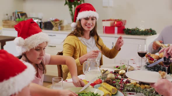 Caucasian girl passing food plate to her mother