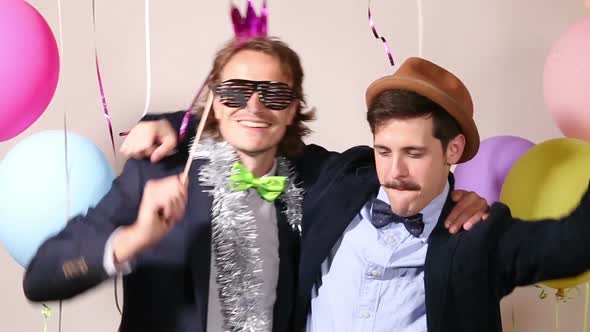 Happy male friends in photo booth