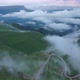 Aerial view on the  green fields at the mountains in the clouds and fog - VideoHive Item for Sale