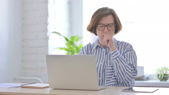 Senior Woman Coughing While Using Laptop