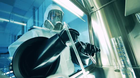 Laboratory Worker is Carrying Out a Research in a Vacuum Cabinet