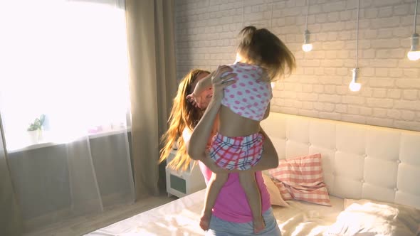 Mom With Daughter At Home On The Bed