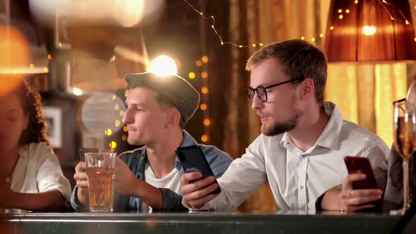 Friends, Men, Women, Leisure, Friendship and Technology Concept - Friends with Smartphones Drinking