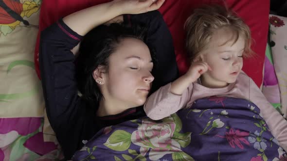 Sleepy Young Woman with Her Baby Does Not Want To Wake Up in the Morning