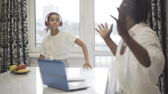 Joyful Teenage Girl Distracting Father From Online Work Home