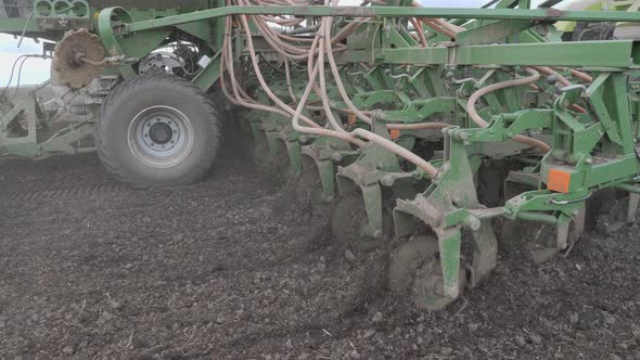 Sowing in the Field. The Seeder Distributes Seeds and Fertilizers Over the Plowed Land. Universal