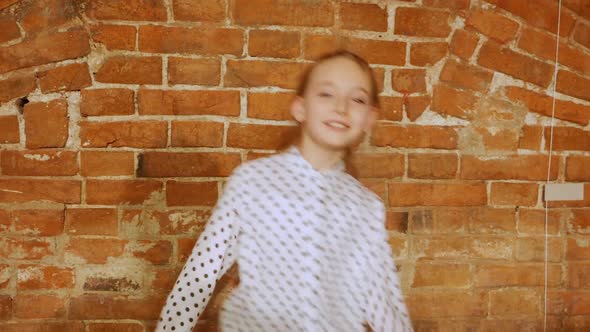 Beautiful Young Girl Dancing Against Brick Wall Background