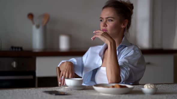 Angry Woman Is Throwing Cell Phone on Table and Touching Her Head, Feeling Ache and Negative Emotion