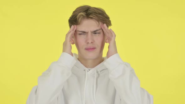 Young Man Having Headache on Yellow Background