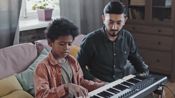 Tutor Teaching Kid Playing Synthesizer