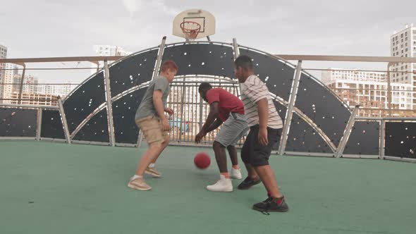 African American Man with Sons Playing Basketball Outdoors