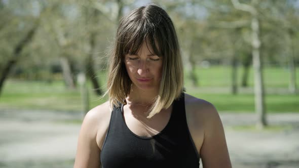 Tired Female Athlete Taking Break During Outdoor Workout