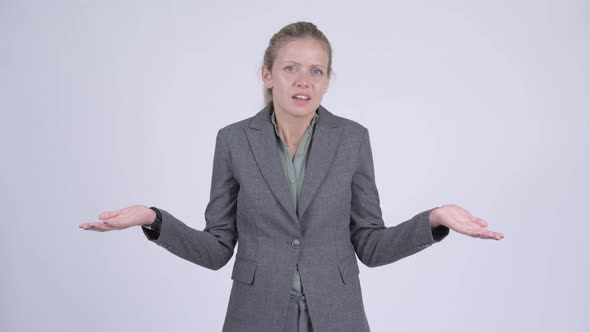 Young Confused Blonde Businesswoman Shrugging Shoulders