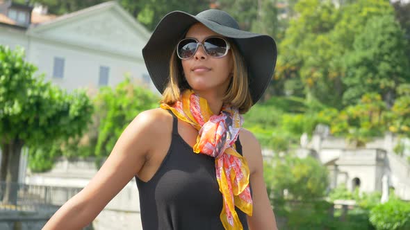 A woman wears a hat while traveling to luxury resort town on a ferry near Lake Como, Italy, Europe